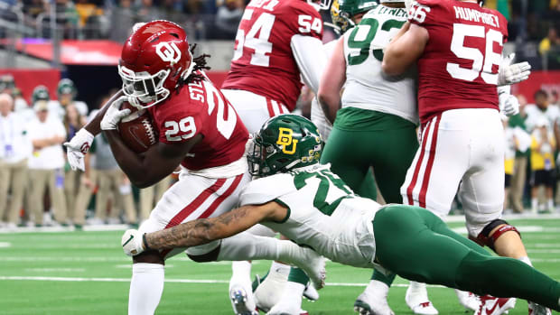 Dec 7, 2019; Arlington, TX, USA; Oklahoma Sooner running back Rhamondre Stevenson (29) runs with the ball for an overtime touchdown against Baylor Bears linebacker Terrel Bernard (26) in the 2019 Big 12 Championship Game at AT&T Stadium.